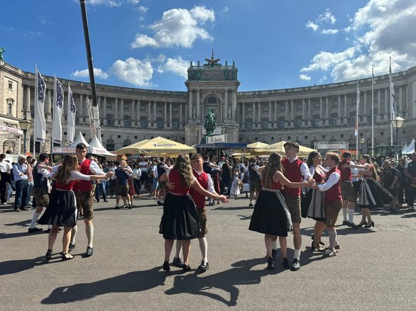 Tanzgruppe in Tracht tanzt am Heldenplatz in Wien vor der Hofburg.